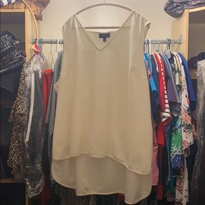 Cream blouse extra long in the back.